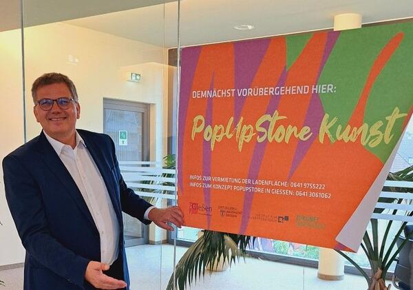 Oberb�rgermeister Becher mit dem Ank�ndigungsplakat f�r den PopUpStore