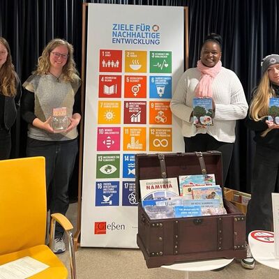 Gruppenbild mit Beteiligten einer Kinderlesung mit Tunaiye Uapingene aus Windhoek  in der Stadtbibliothek. v.l.n.r.: Tabea Knispel (Stadtbibliothek), Janina Brendel (Referentin f�r Internationales, St�dtepartnerschaften und Fairtrade), Autorin Tunaiye Uapingene und Cinja Kissel (Bildungskoordinatorin des Weltladens Gie�en)