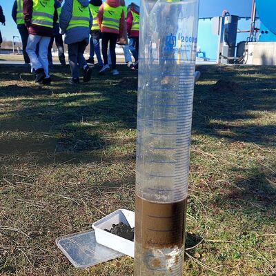In einem Glaskolben mit Abwasser haben sich Feststoffe abgesetzt.
