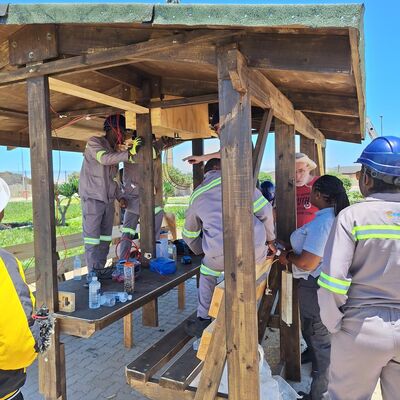 Auszubildende, Trainees, Sch�ler, Ausbilderin und Ausbilder arbeiten Hand in Hand beim Entstehen der Begegnungsinseln.