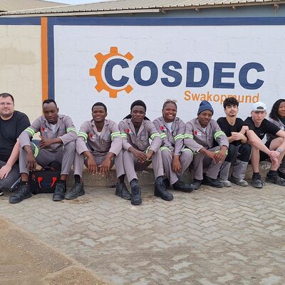 Sch�ler und Auszubildender aus Gie�en gemeinsam mit Trainees aus Swakopmund vor dem dortigen Community Skills and Development Center.