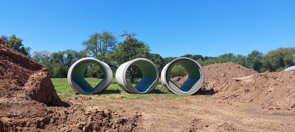 Auf dem Foto sieht man drei von den insgesamt 155 Stahlbetonrohre die unter der Lahnwiese verbaut wurden. Jedes Rohr ist etwa 25 Tonnen schwer und 5 Meter lang.