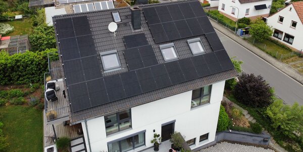 Luftaufnahme eines Wohnhauses mit Photovoltaik-Modulen auf dem Dach