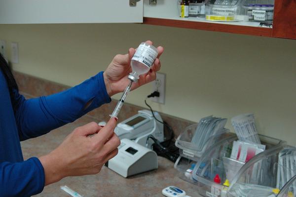 Krankenschwester zieht eine Impfspritze auf