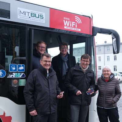 Gruppenbild mit Vertretern von SWG, MIT.BUS und Stadt vor einem Bus mit WLAN