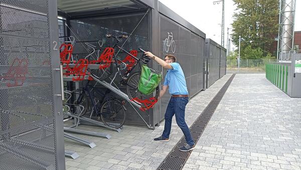 Ein Radfahrer stellt ein Rad in den Sammelgaragen am Bahnhof ab