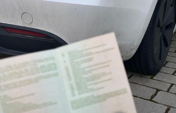 Ausschnitt eines Fahrzeugschens vor einem PKW - Symbolbild